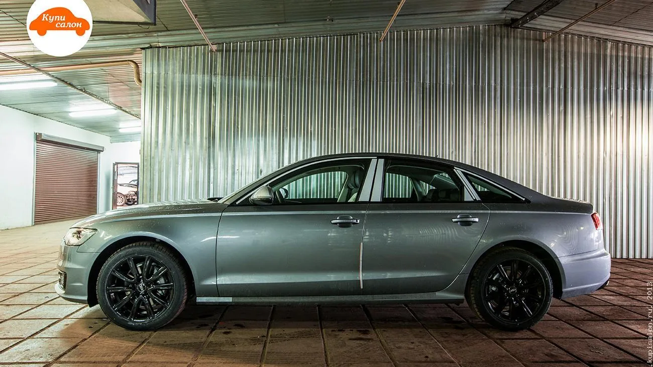 Серый седан Audi A6 с черными дисками, вид сбоку в гараже