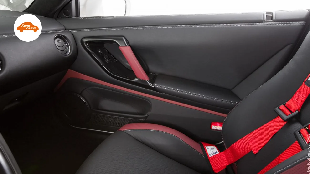 Перетяжка салона Nissan GT-R: дверные карты и сиденья в черной коже с красными вставками и красными ремнями Sparco.